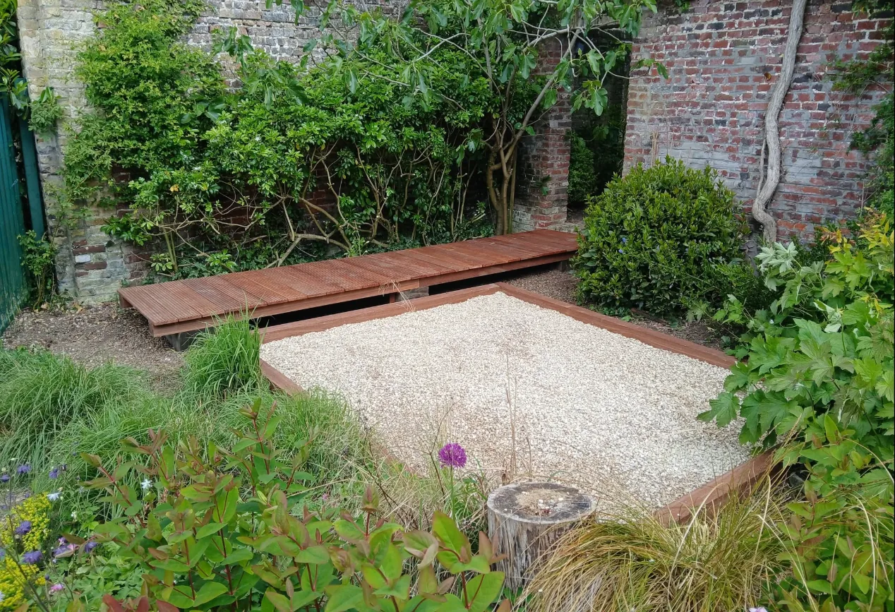 Jardin zen avec platelage bois neuf, gravier clair et banc intégré, réalisation MAC Paysages à Rexpoëde