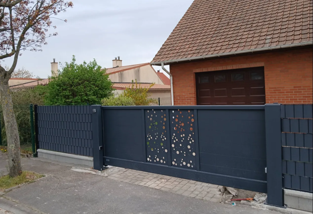 Portail coulissant anthracite avec motif à pastilles découpées, réalisation MAC Paysages à Rexpoëde